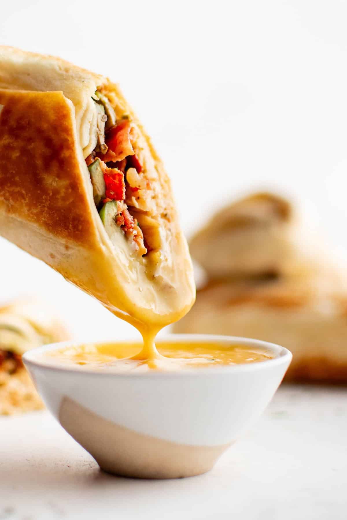 pepper jack chicken wrap being dipped into honey mustard