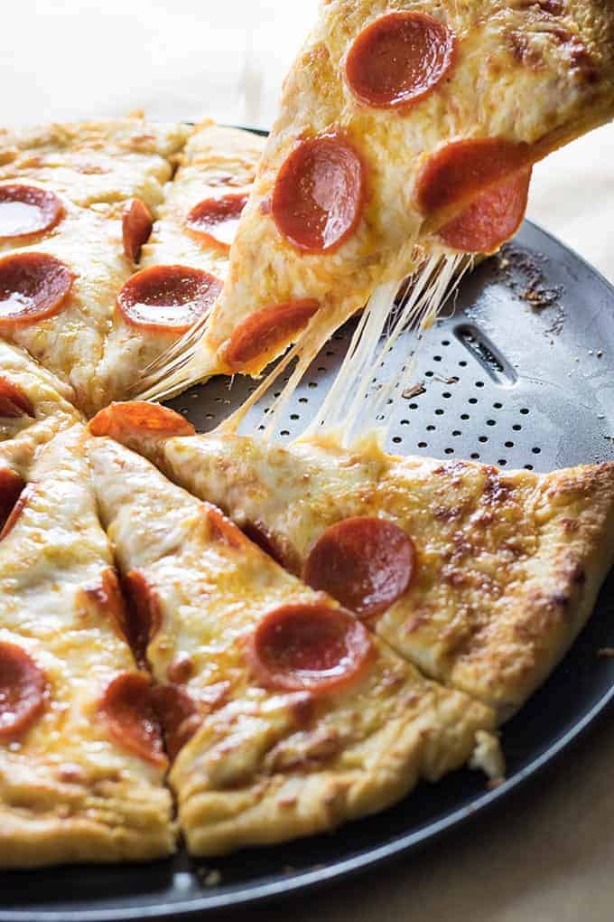 pizza slice being lifted from pizza pan