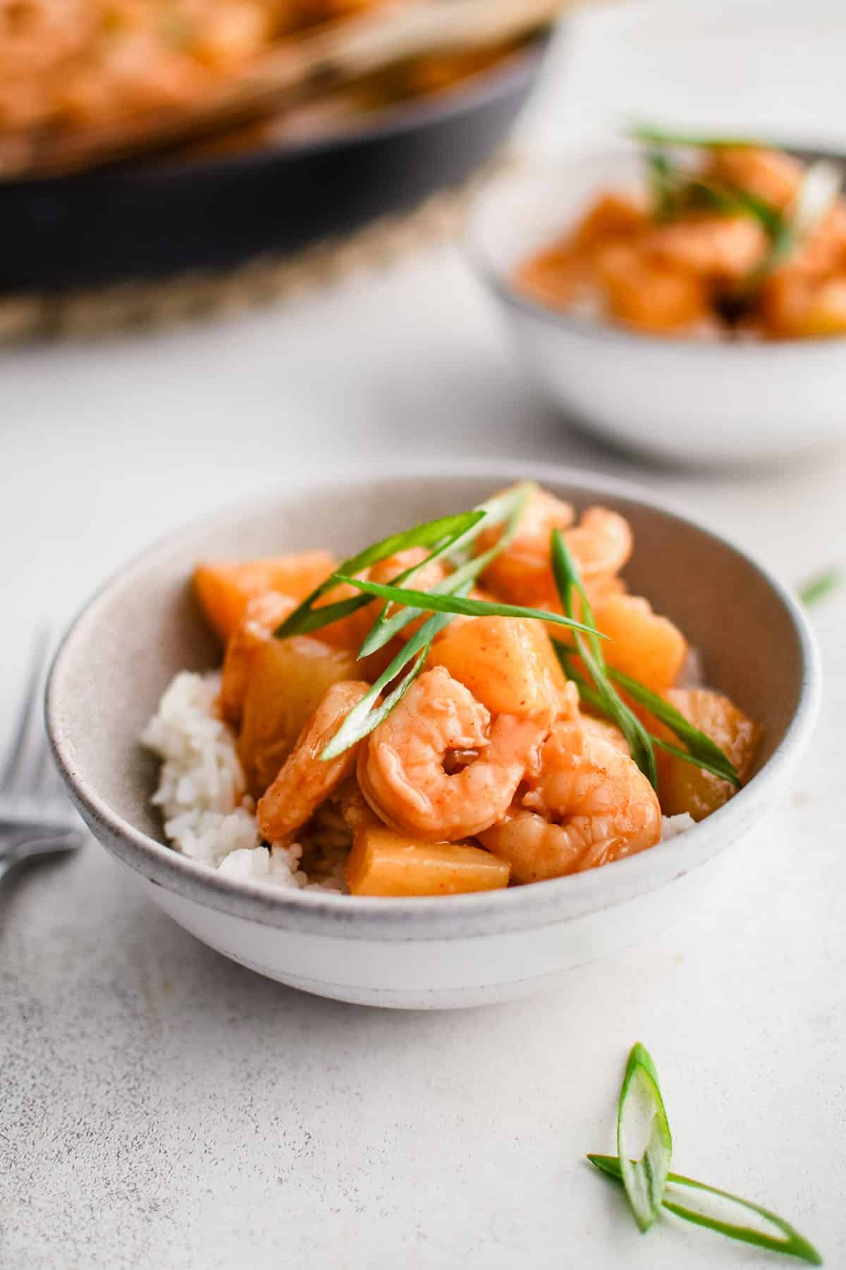 sweet chili shrimp in a bowl over rice and topped with sliced green onions