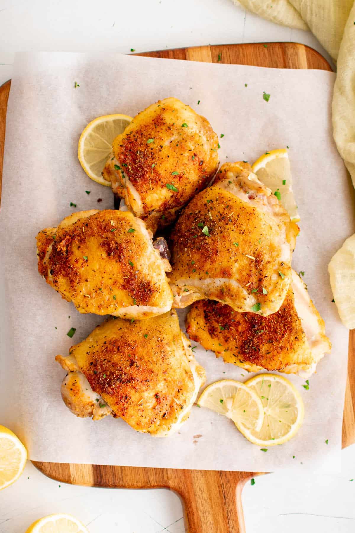 lemon pepper baked chicken thighs on a serving board