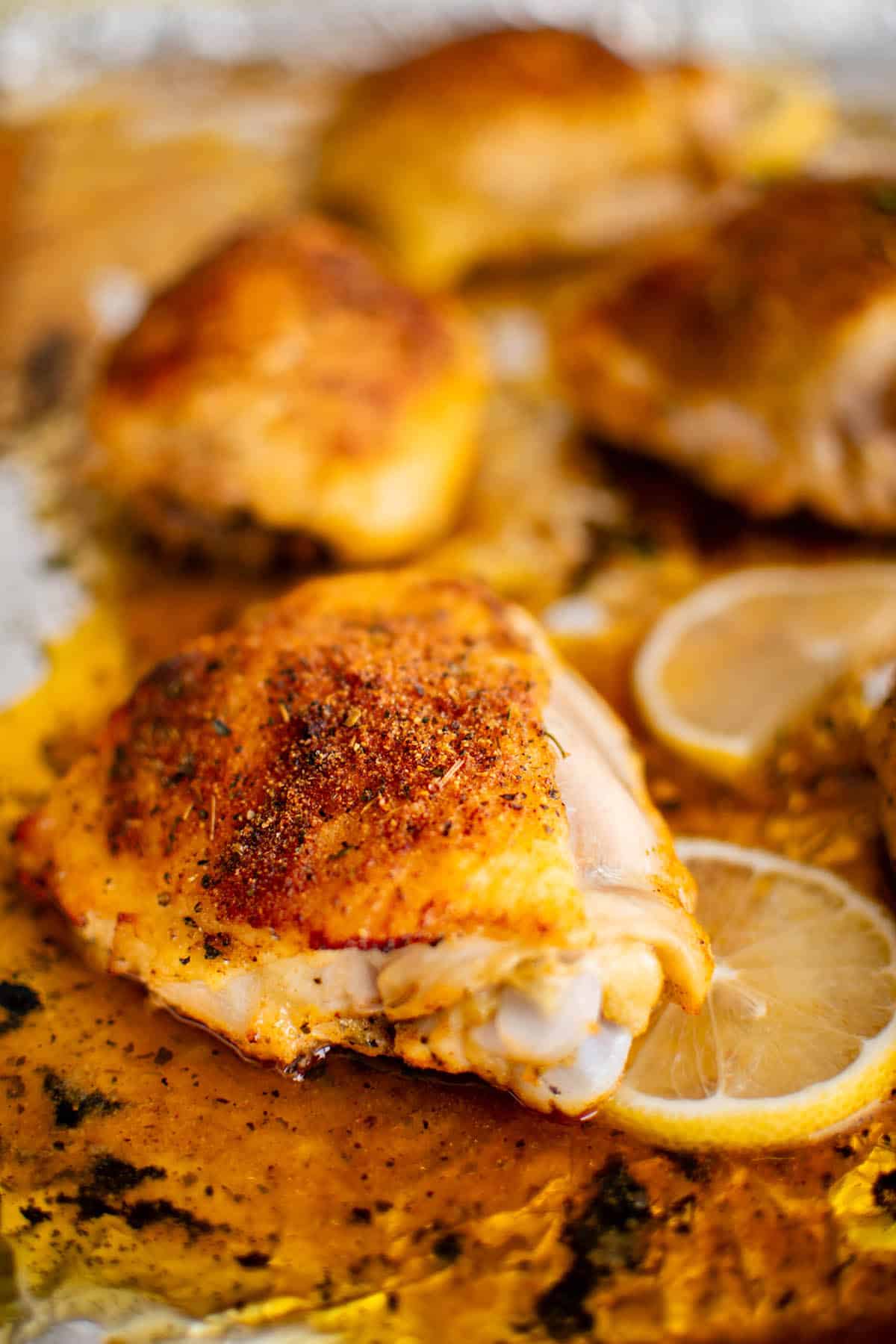 close up photo of a lemon pepper baked chicken thigh