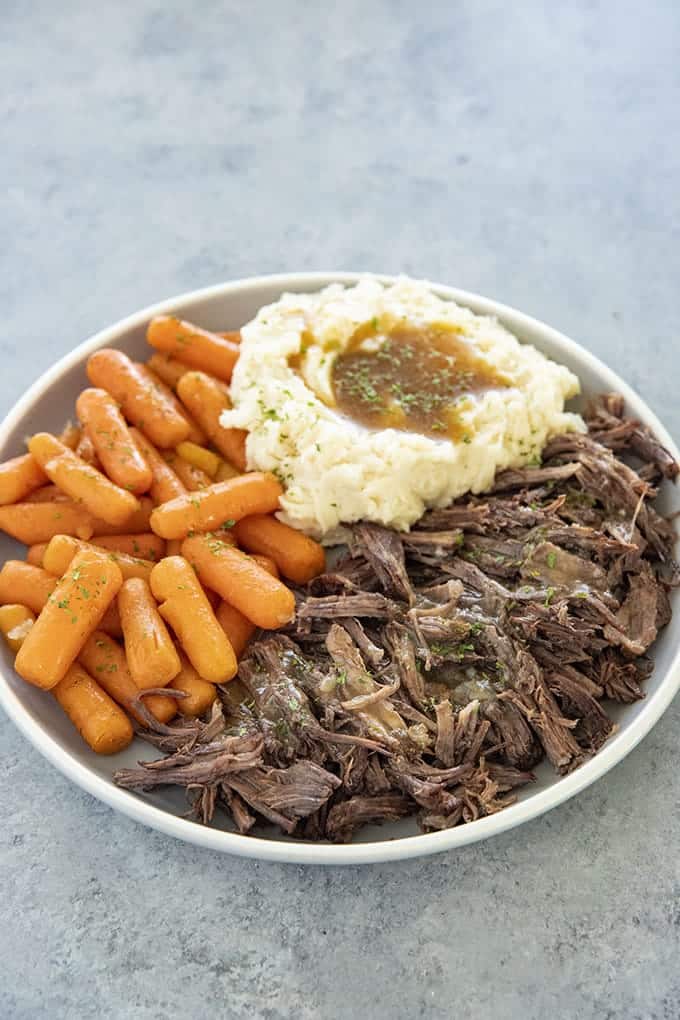 instant pot roast on plate with mashed potatoes and carrots