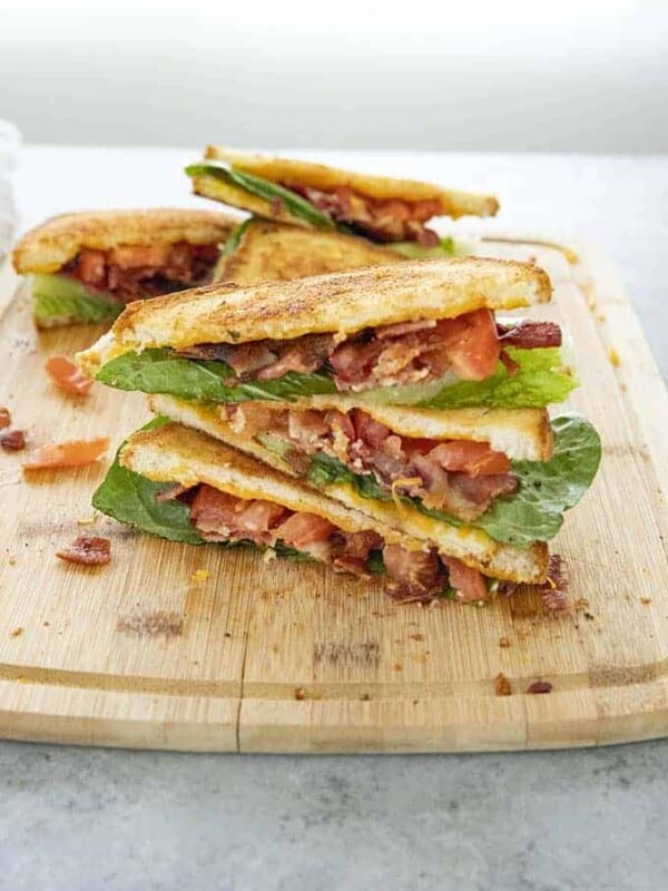 blt with cheesy garlic bread stacked on cutting board