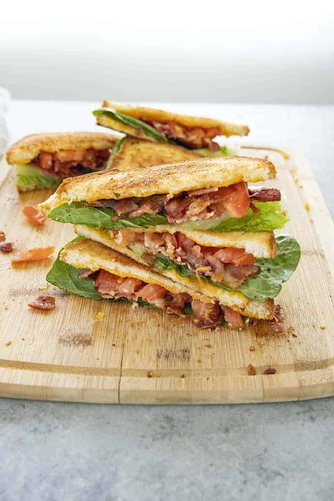 blt with cheesy garlic bread stacked on cutting board