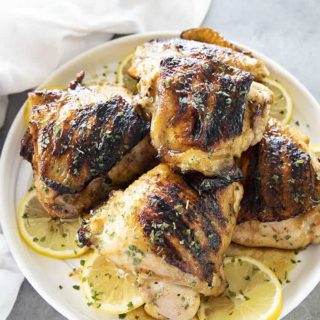 grilled chicken thighs on a white plate