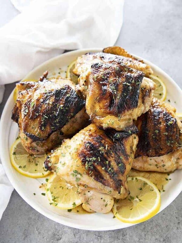 grilled chicken thighs on a white plate