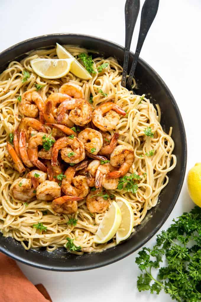 Cajun shrimp pasta in a pan with lemons and parsley