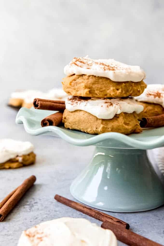An image of soft pumpkin cookies with cream cheese frosting on a small cake stand.