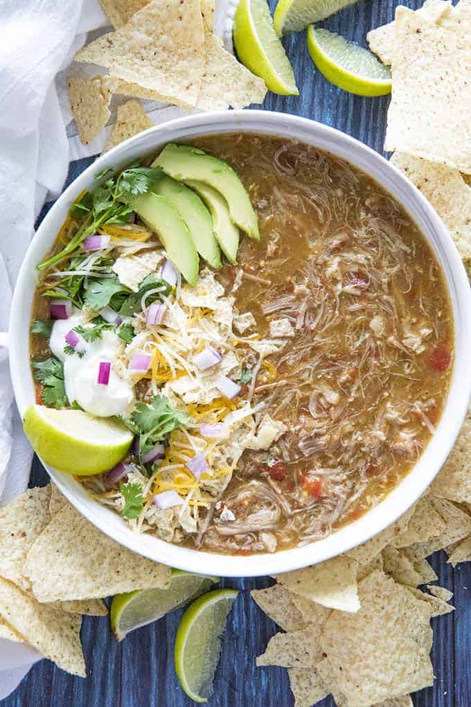 green chili made in instant pot in a large bowl with toppings