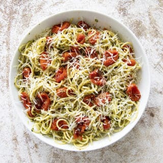 pasta in a bowl with pesto and roasted tomatoes
