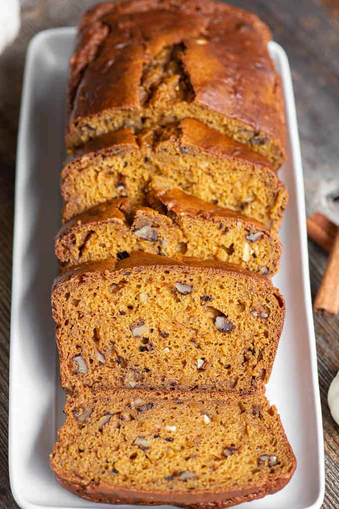 sliced loaf of pumpkin bread on white rectangle platter