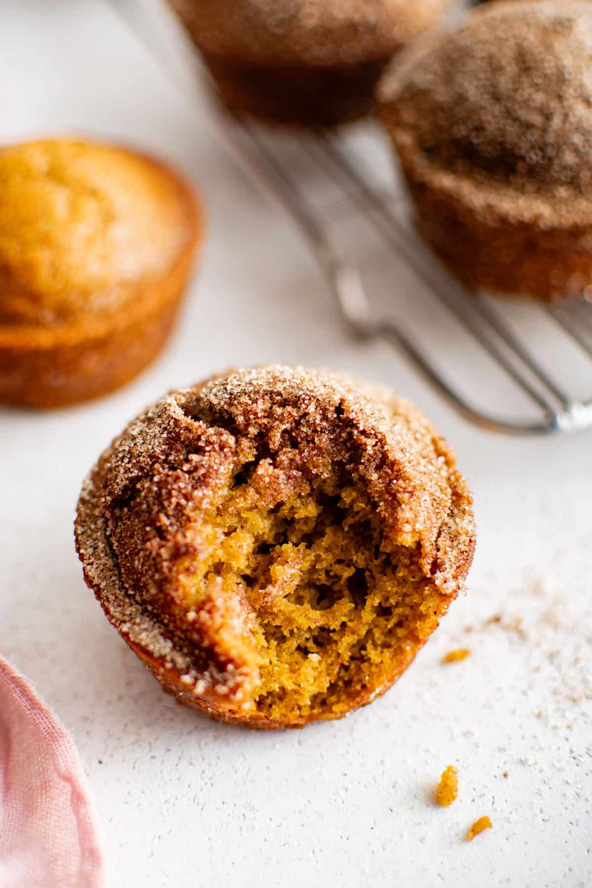 pumpkin muffin with a bite taken out of it showing its soft texture