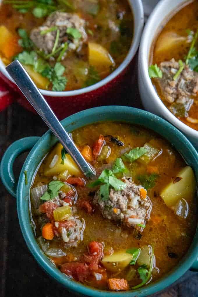 albondigas soup with three bowls and a spoon