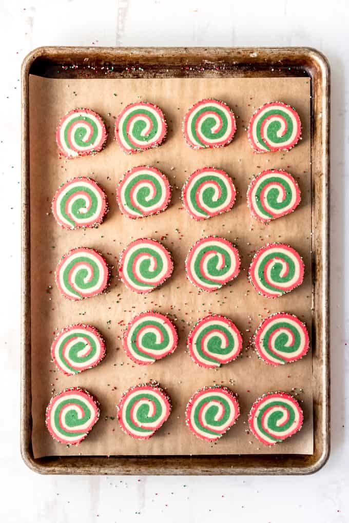 An image of slice-and-bake pinwheel cookies on a baking sheet lined with parchment paper.
