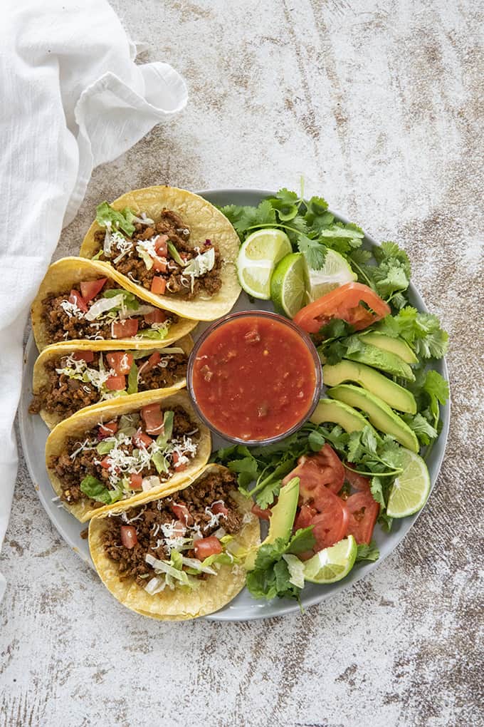 beef tacos on a plate with toppings