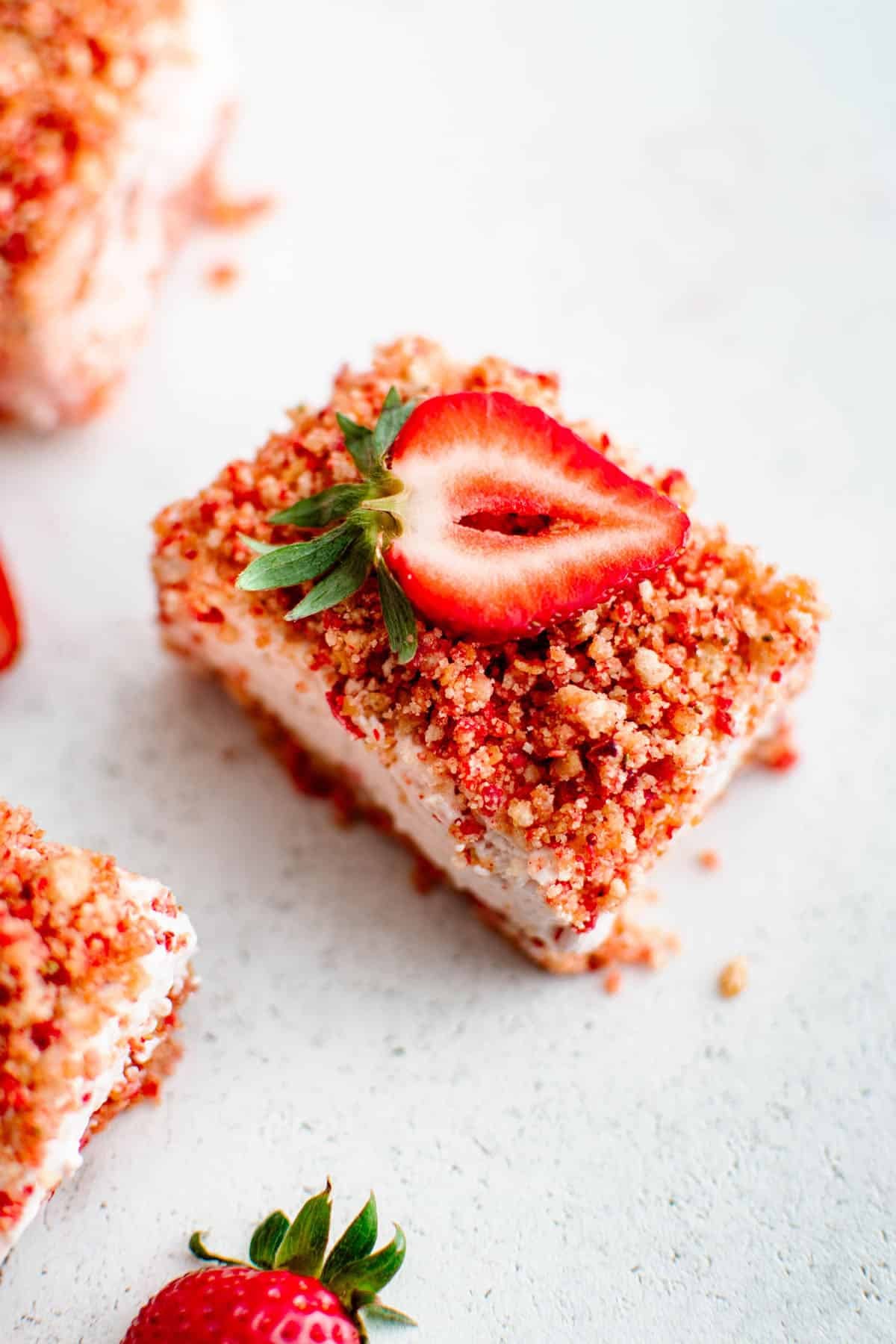 strawberry cheesecake bar with a fresh sliced strawberry on top of it