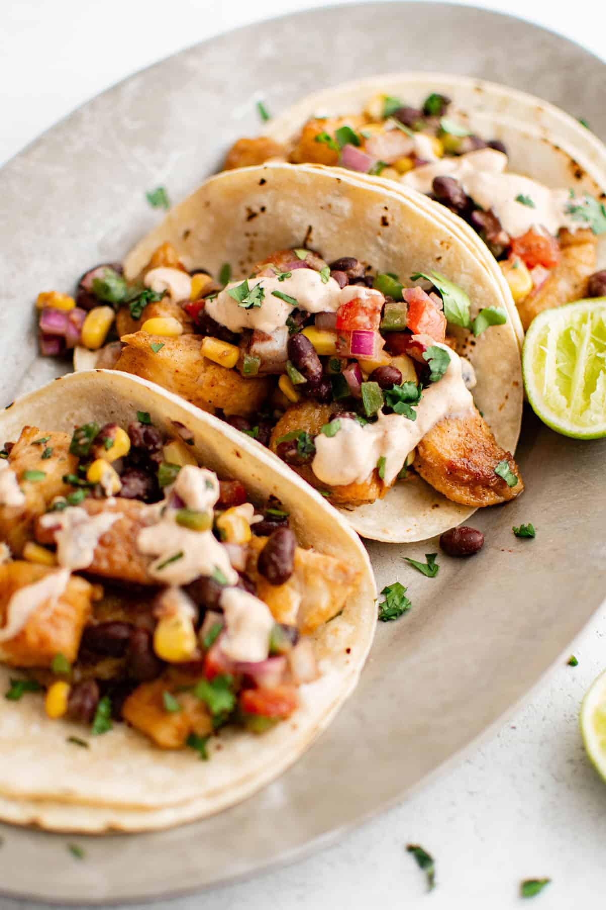 best fish tacos with homemade sauce drizzled over them