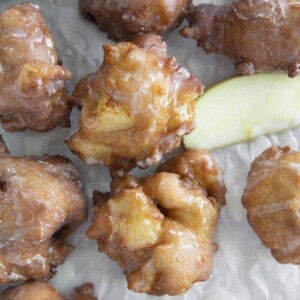 photo of apple fritters on parchment paper