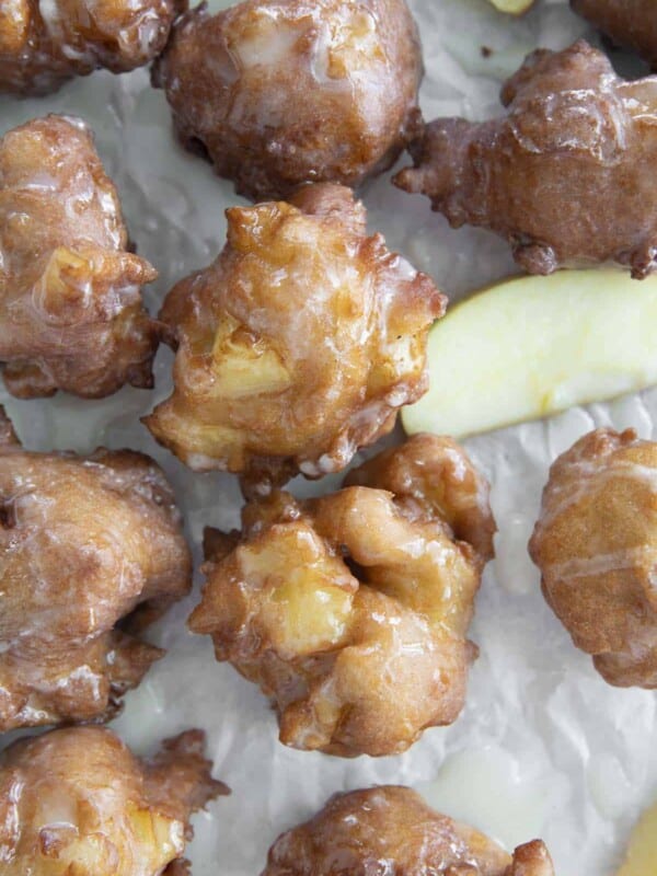 photo of apple fritters on parchment paper