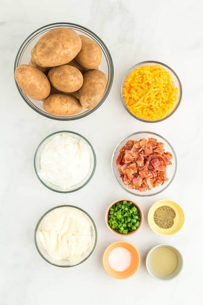 ingredients to make baked potato salad on a white board