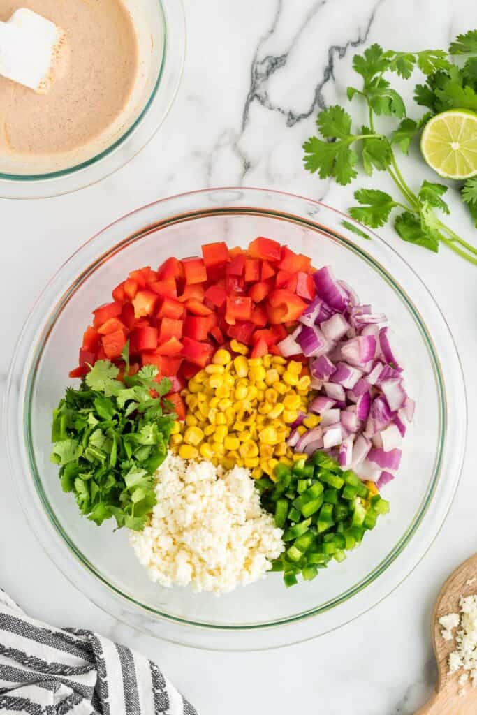 ingredients for mexican street corn salad in a mixing bowl