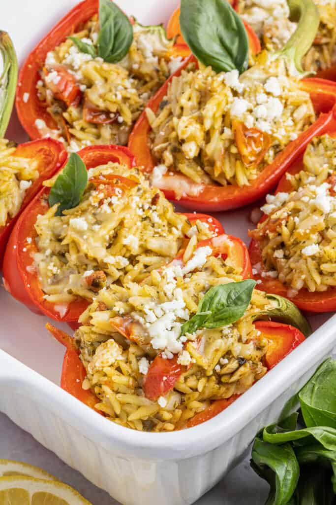 orzo stuffed red bell peppers in a dish