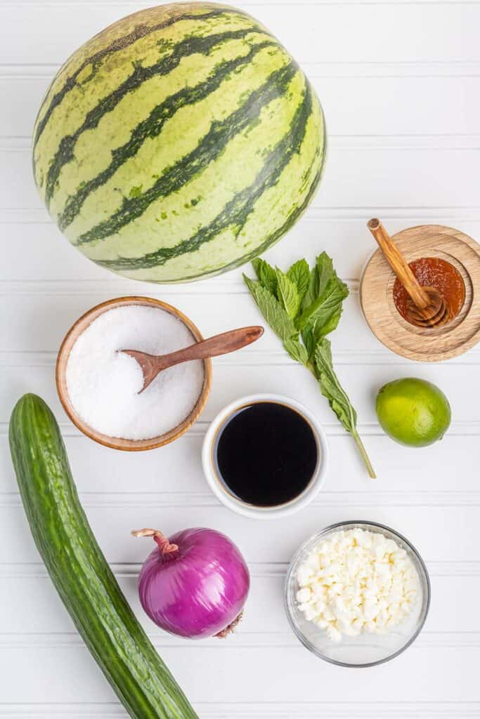 ingredients for watermelon salad on a white board