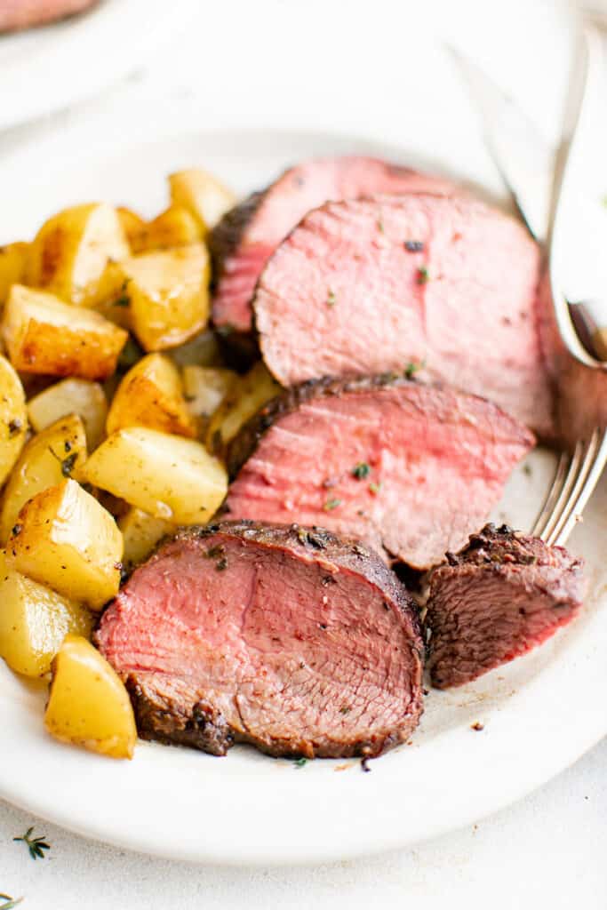 beef tenderloin on a plate with potatoes