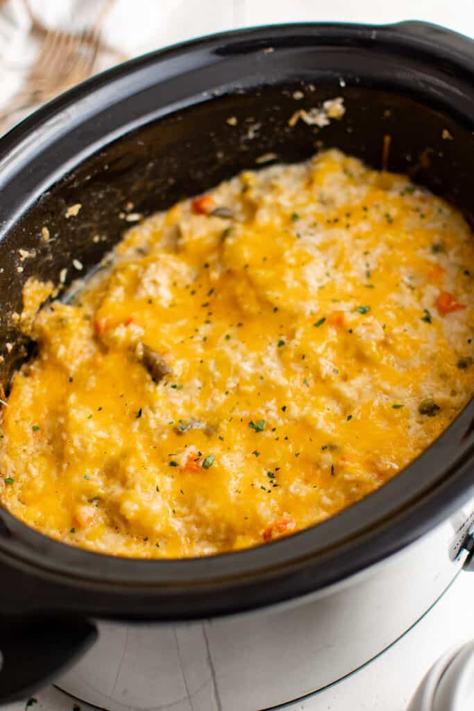 chicken and rice topped with cheese in the crockpot