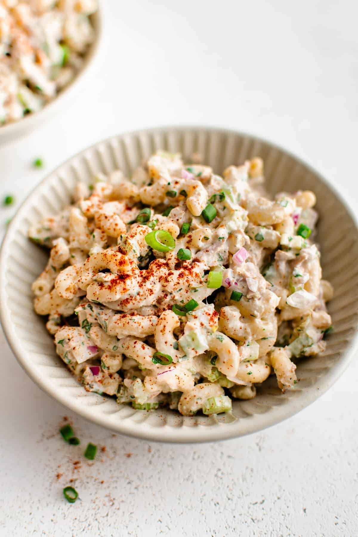 tuna pasta salad in a bowl garnished with green onions