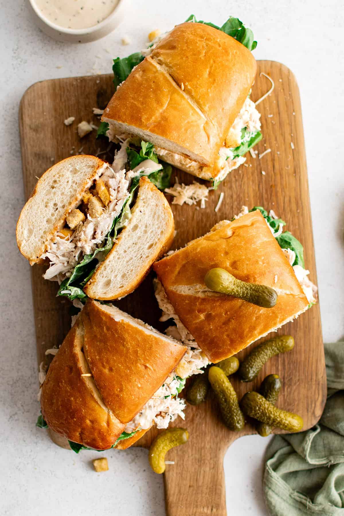 sandwiches with chicken caesar filling on a cutting board