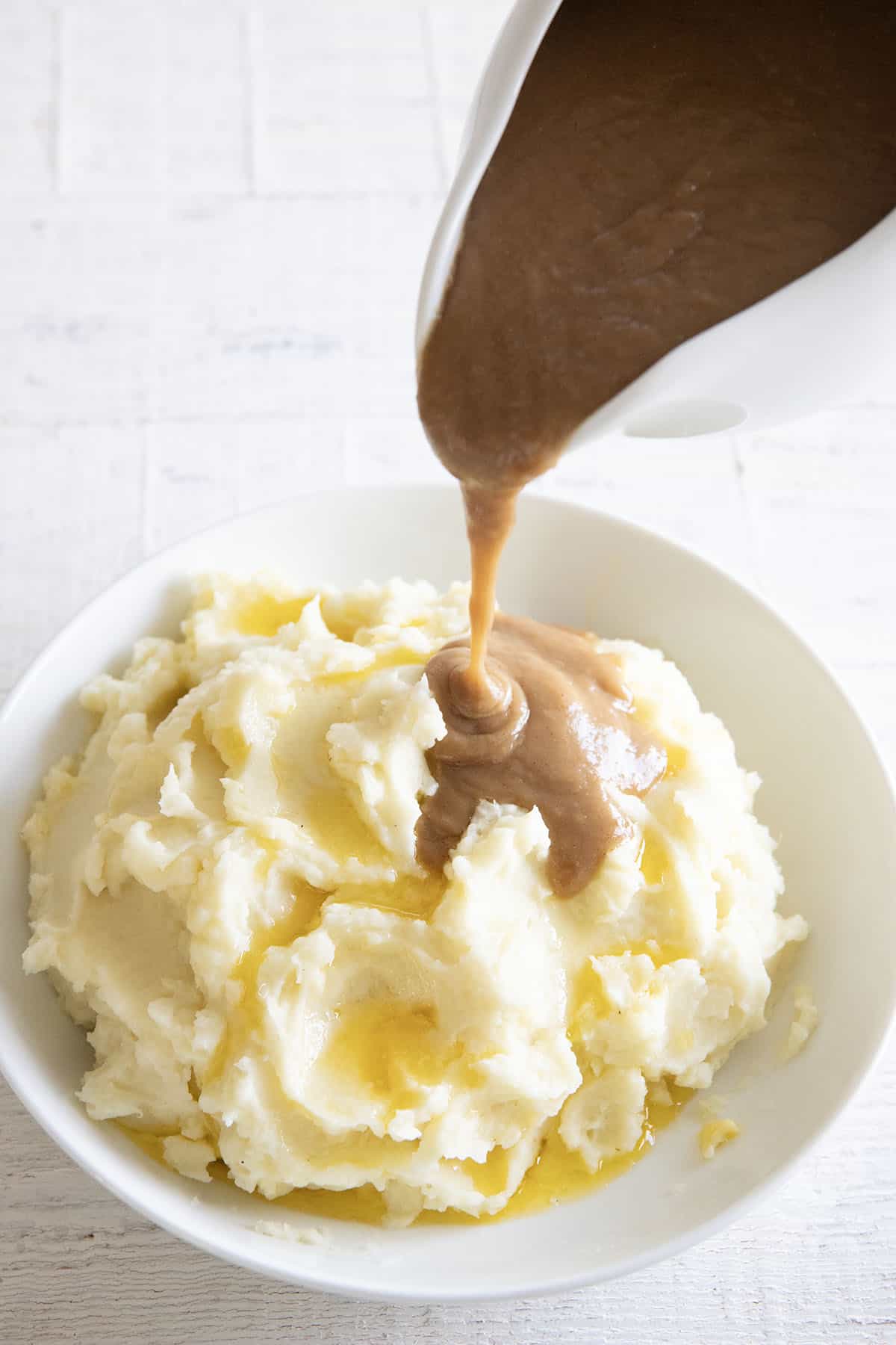 brown gravy being poured onto mashed potatoes