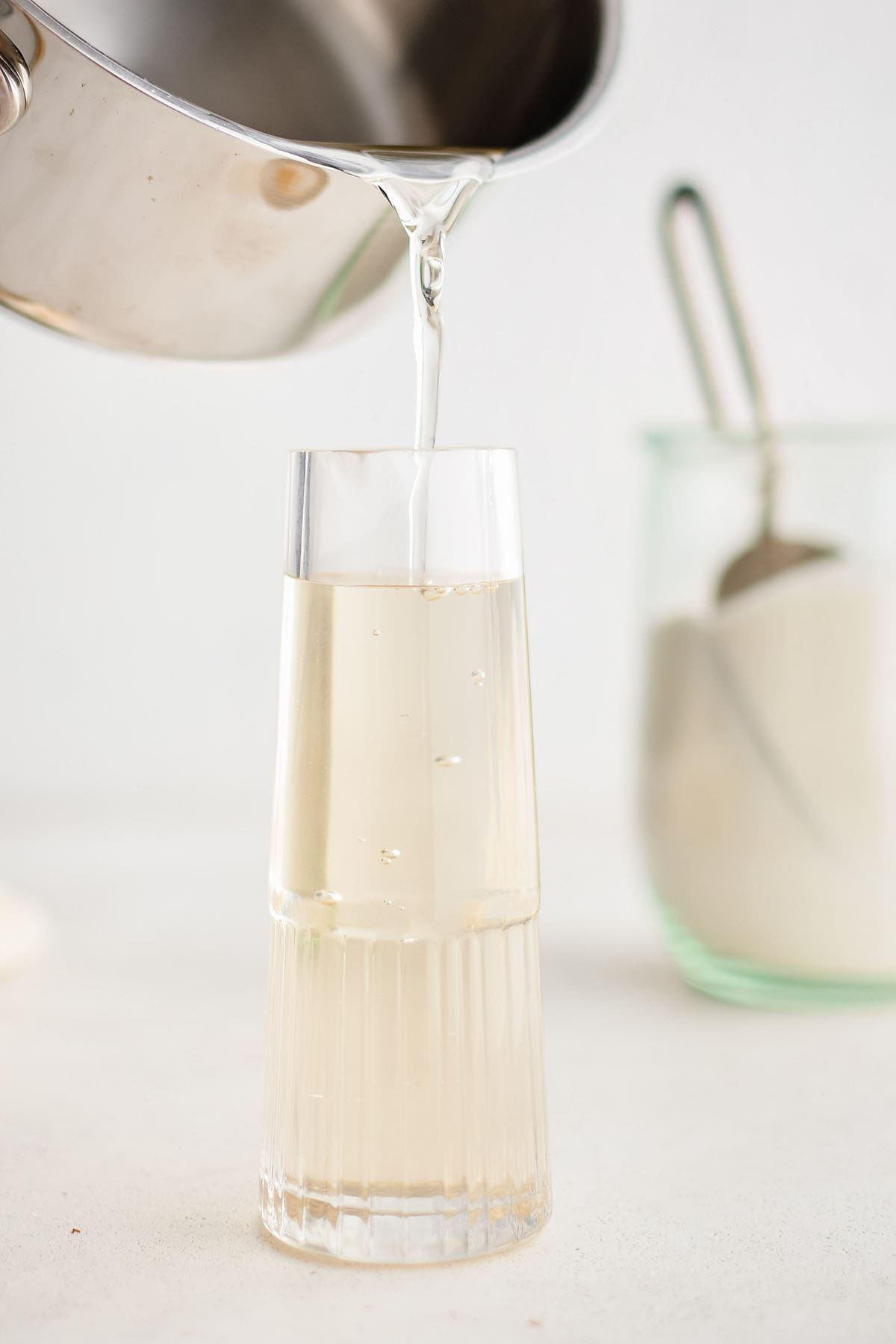 photo showing simple syrup being poured intoa bottle