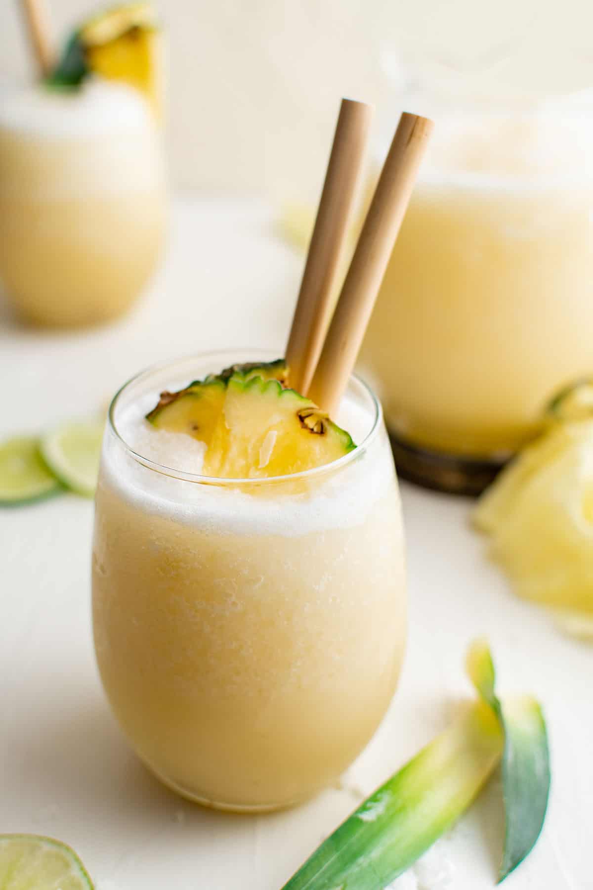 photo of a pina colada in a glass with two straws