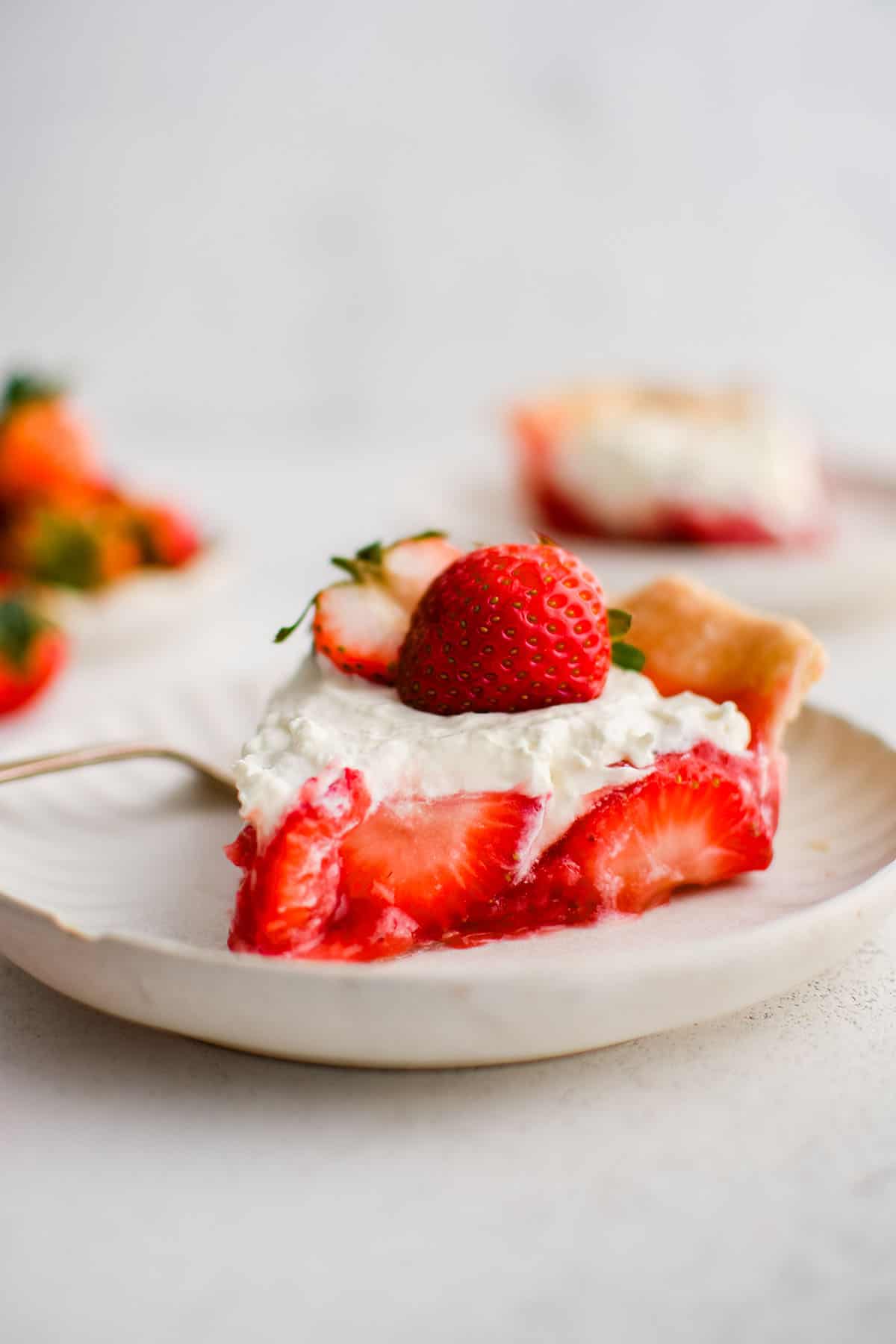 slice of strawberry pie on a plate with whipped cream