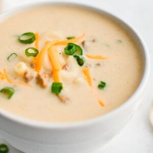 cheesy hamburger soup in a white bowl