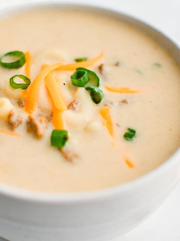 cheesy hamburger soup in a white bowl