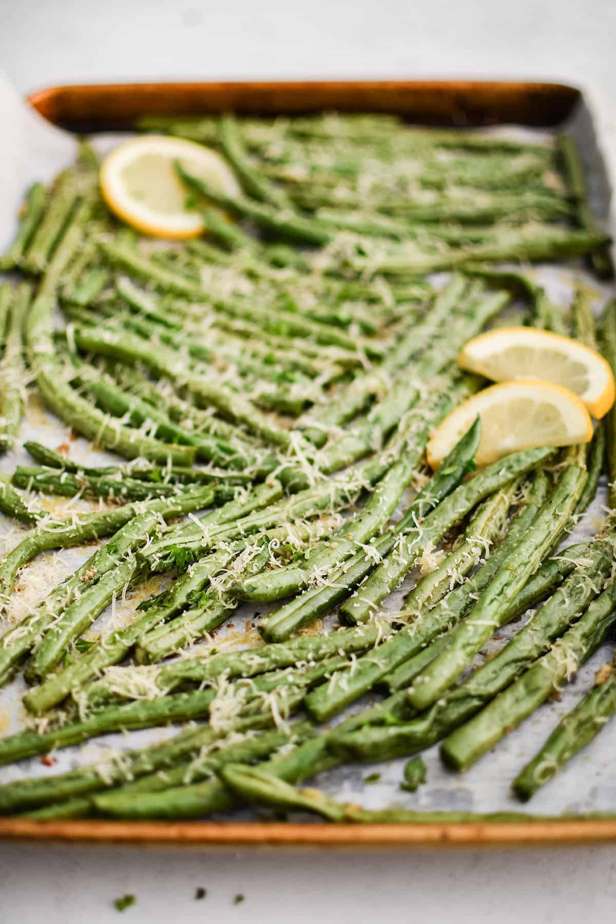 roasted green beans on a sheet pan with lemon