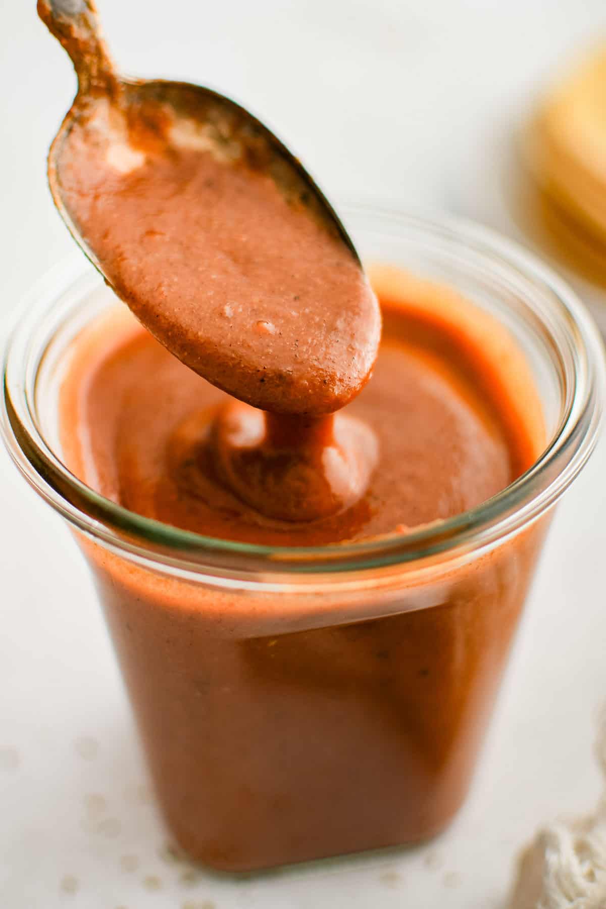 enchilada sauce in a glass jar with a spoon