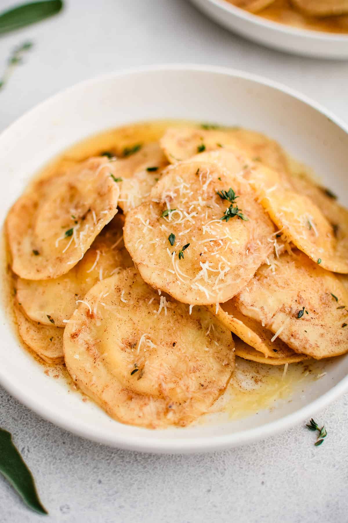 ravioli with brown butter garlic sauce in a white bowl