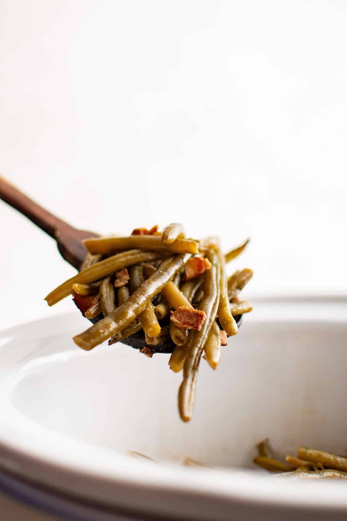 crockpot green beans on a wooden serving spoon