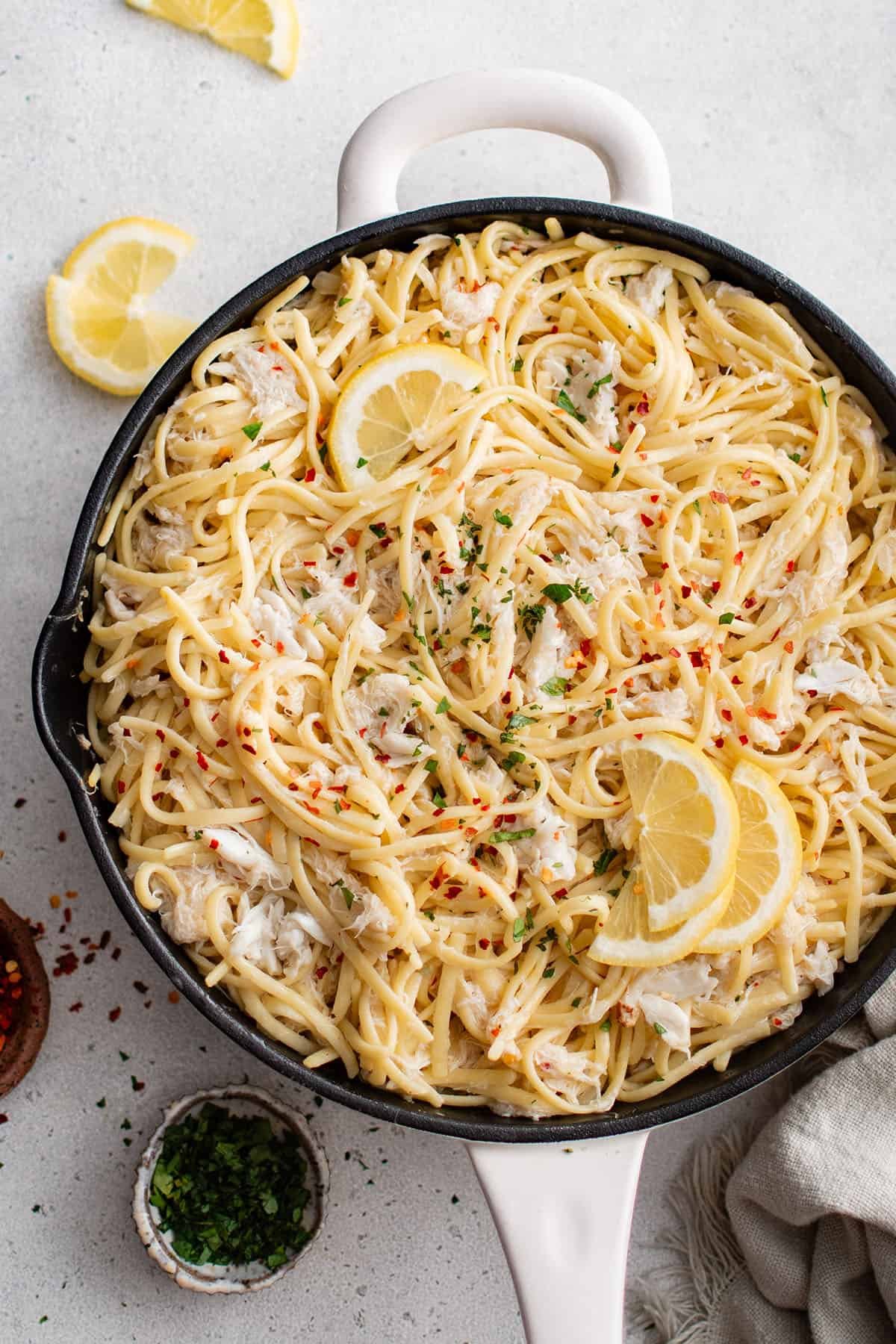 photo of crab pasta in a pan topped with lemons