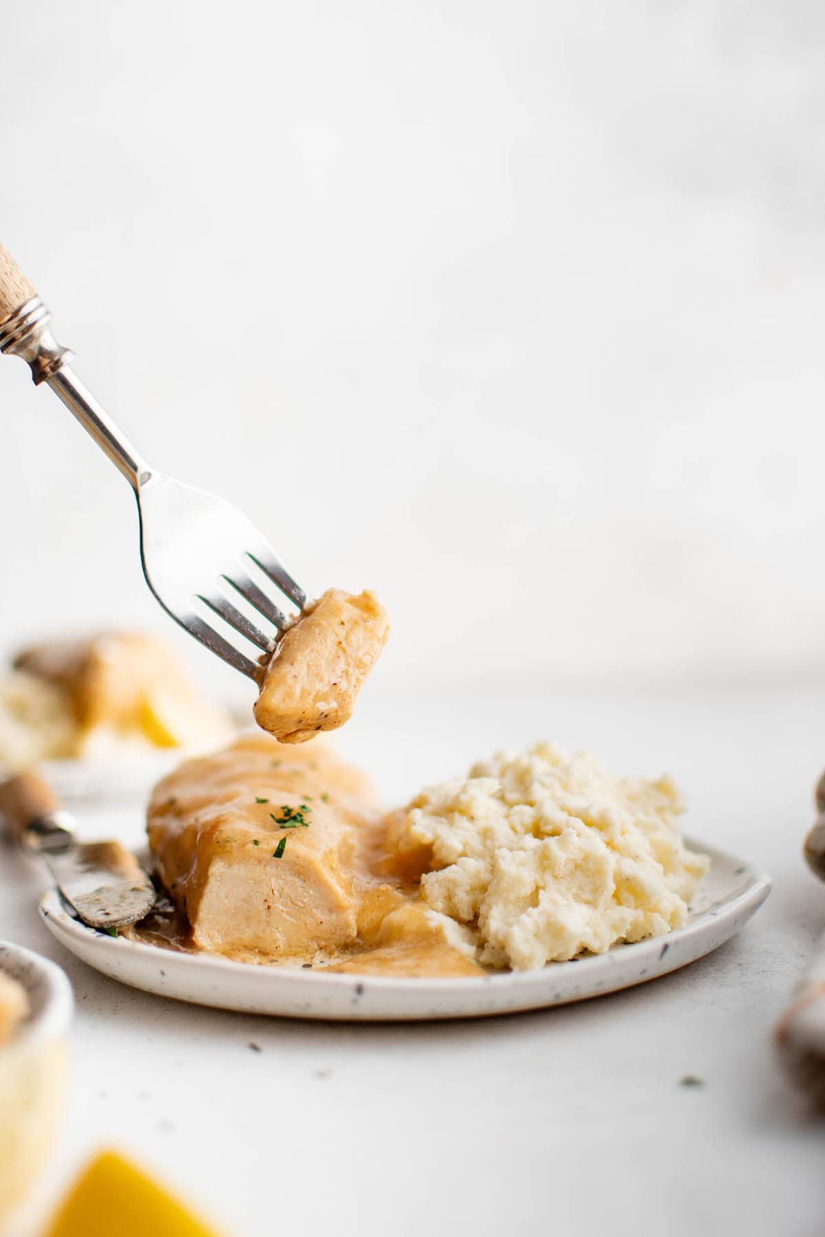 a piece of crockpot lemon pepper butter chicken on a fork 