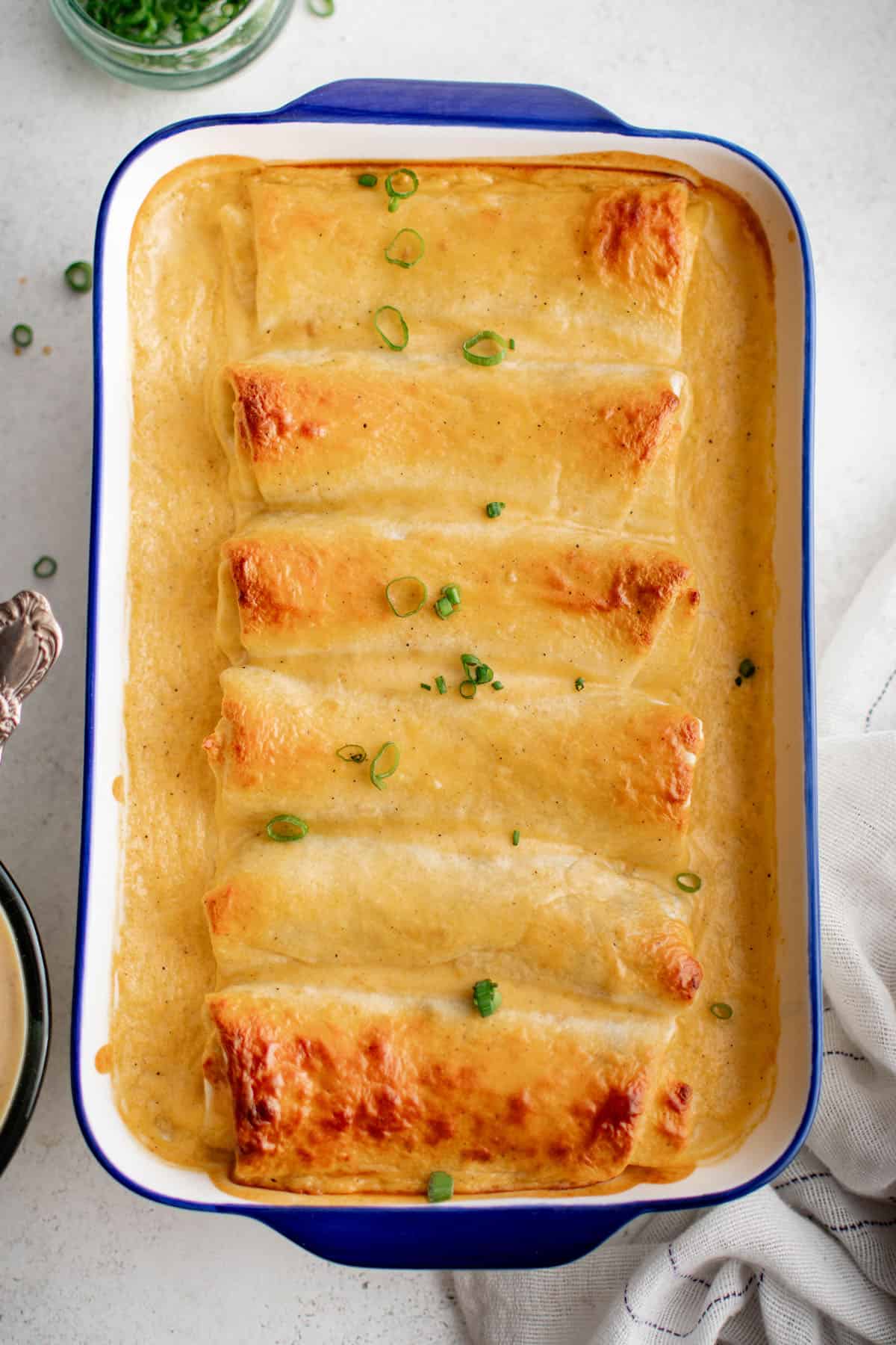 smothered bean & cheese burritos in a baking dish