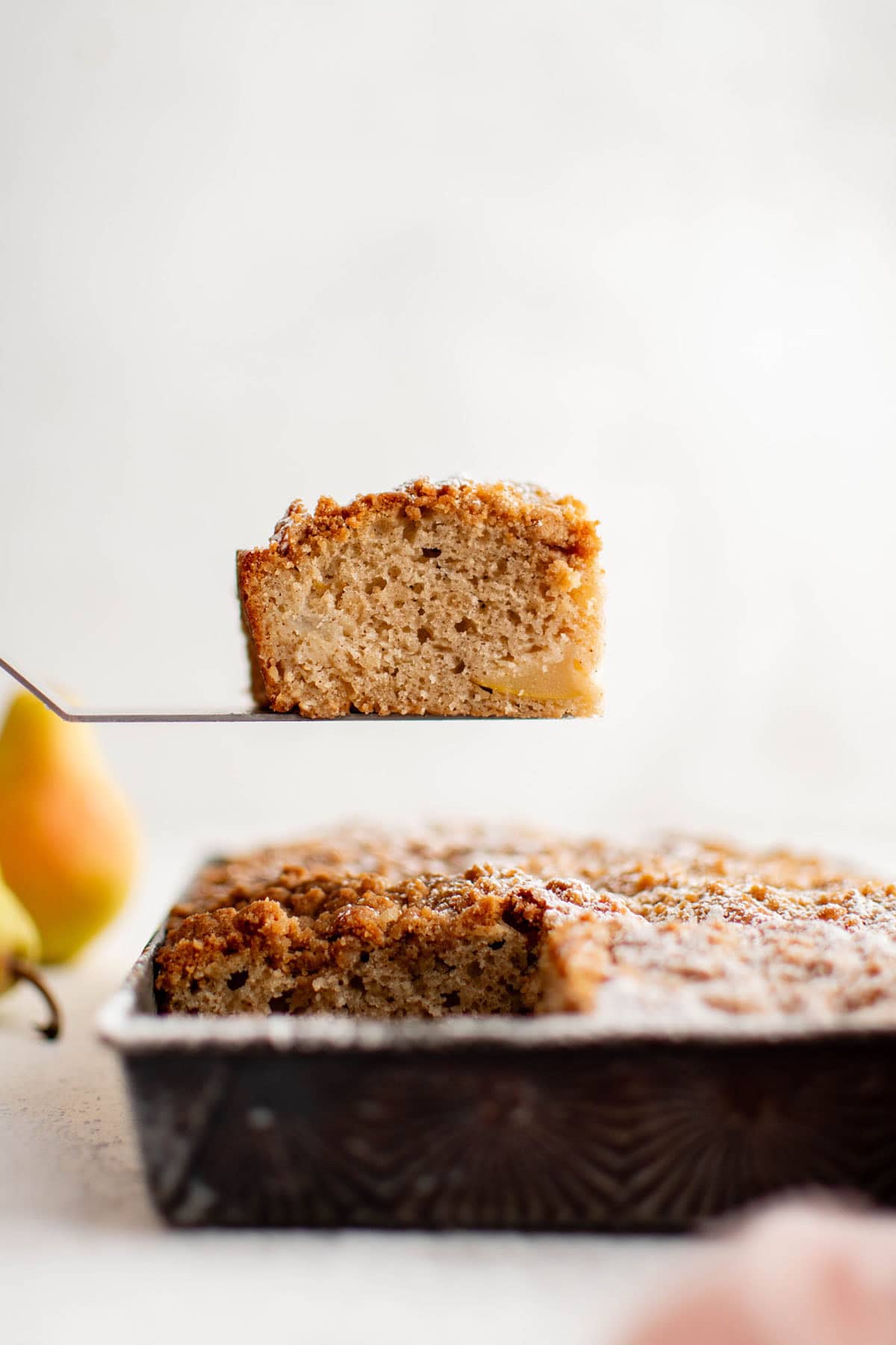 slice of chai spiced pear coffee cake on a serving spoon