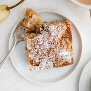 chai spiced pear breakfast cake on a white plate with a fork