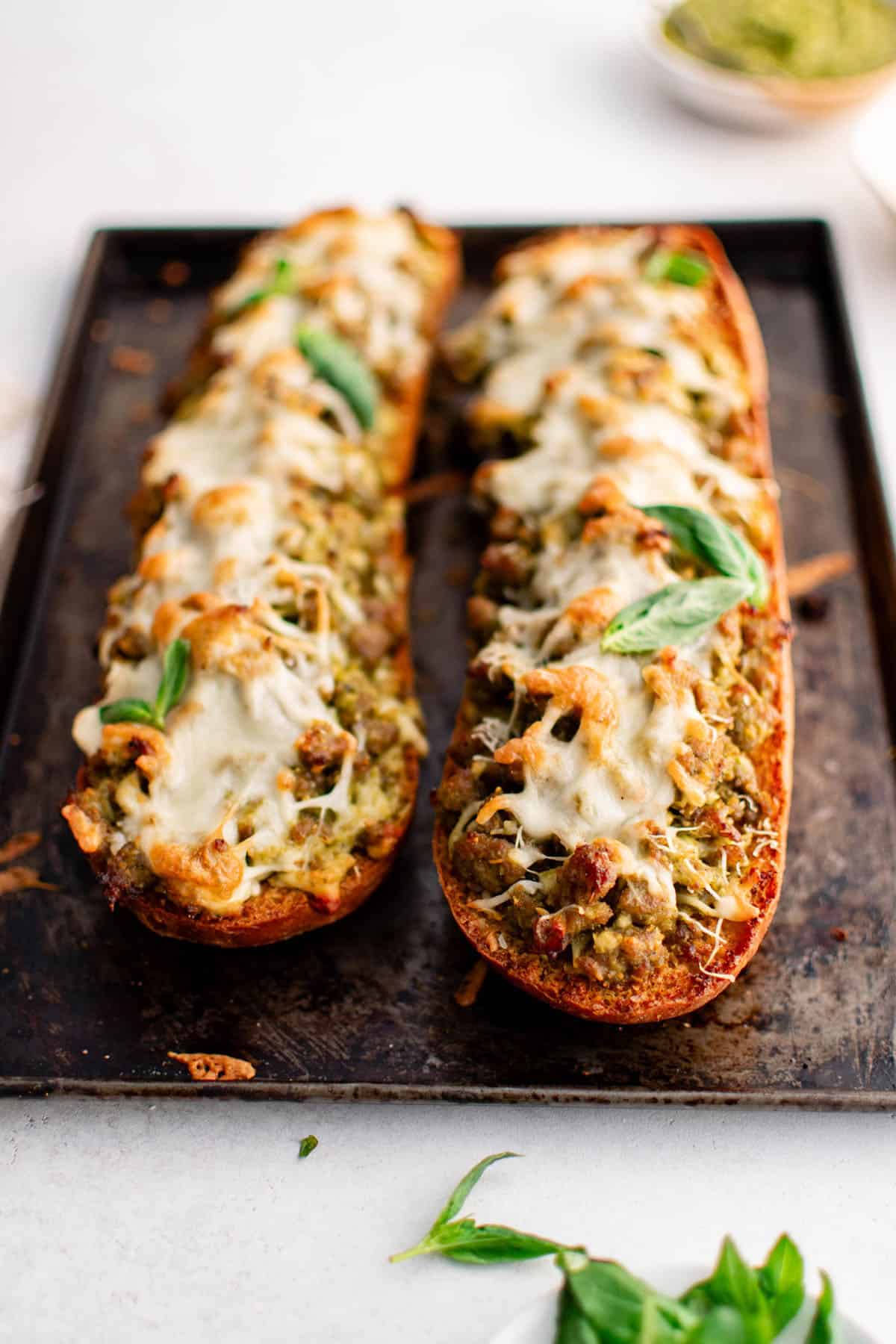 sausage pesto garlic bread on a baking sheet