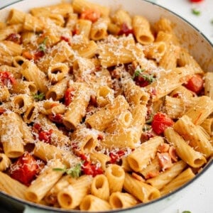 bacon pasta with tomato in a white skillet