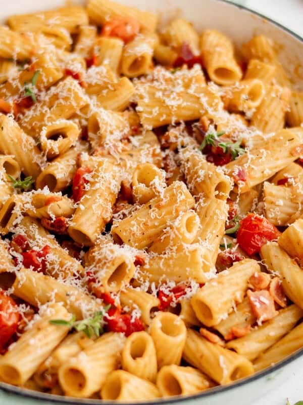 bacon pasta with tomato in a white skillet
