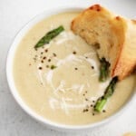 bowl of creamy asparagus soup with bread